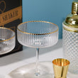 Load and play video in Gallery viewer, Gold cocktail shaker set with 2 ribbed coupe glasses, jigger, and bar spoon in luxury gift box.