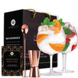 Load image into Gallery viewer, A set of handcrafted crystal gin glasses with bar accessories including a bar spoon, shot measure, and a recipe e-book, presented in a black gift box with gold accents.