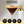 Load image into Gallery viewer, Espresso martini in ribbed martini glass with gold rim beside cocktail shaker.
