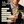Load image into Gallery viewer, Two Vemacity stemless martini glasses with gold rims, filled with martinis and garnished with olives, held in a celebratory toast.
